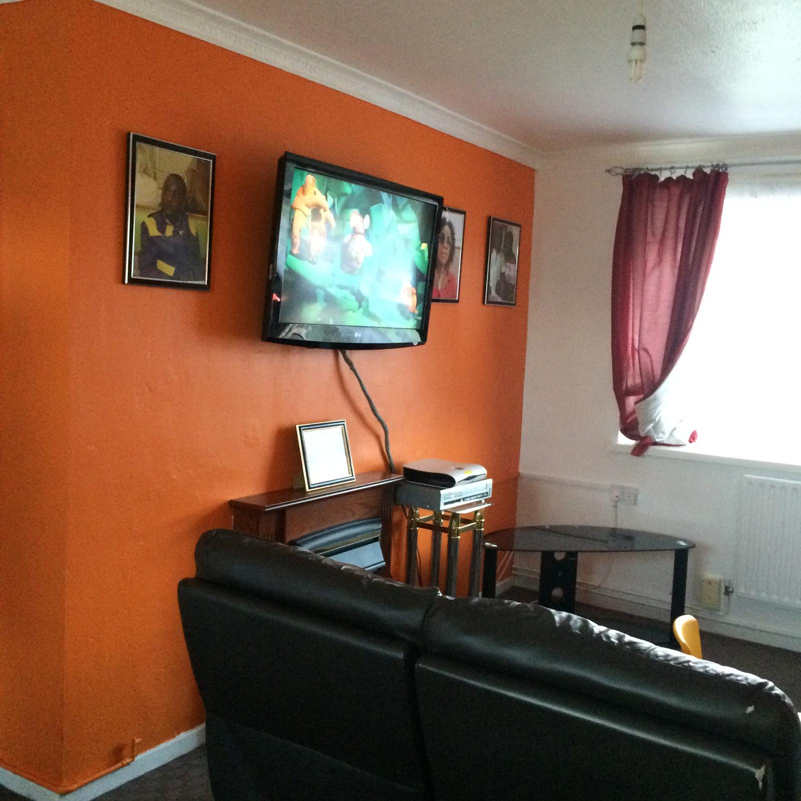 Living room finished in orange with a white ceiling and coving