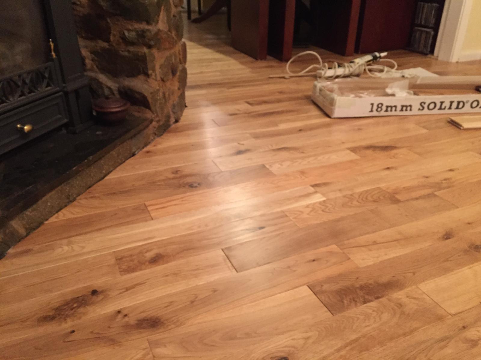 Solid oak flooring laid up to a stone fireplace hearth