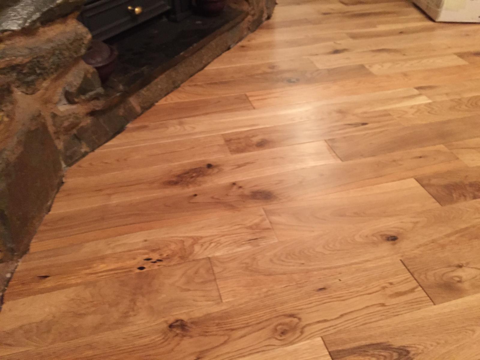 Close view of oak boards scribed around a stone fireplace